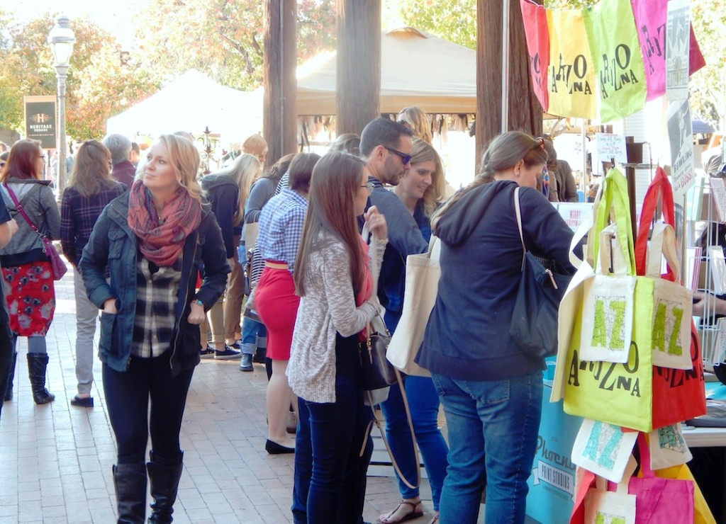 A festival at Heritage Square with lots of people and bright colors.