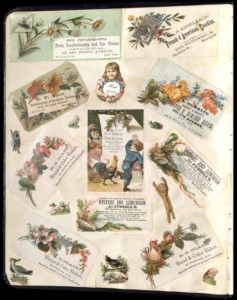 A page from a scrapbook containing several colorful cards advertising businesses and featuring flowers, animals, and children