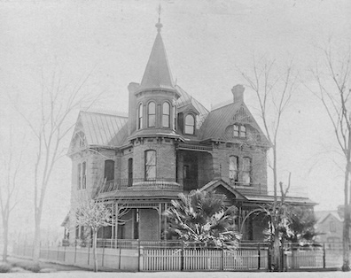 A photo of a brick, Queen Anne style house, taken circa 1908.